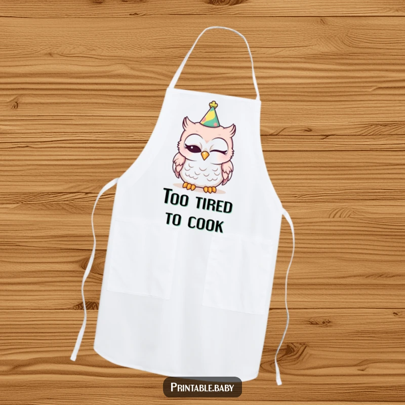 Funny sleepy baby owl wearing a party hat, one eye closed, on a kitchen apron, great for cooking fun.